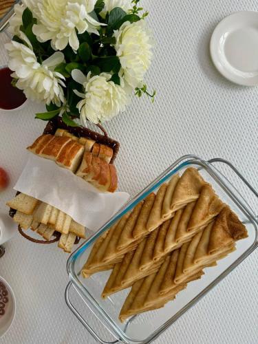a table with a tray of waffles and a vase with flowers at Forest and Lake in Borovoye