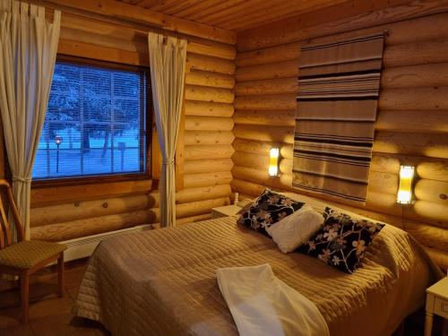 a bedroom with a bed in a log cabin at Tahko Hovimäenraitti 5A in Tahkovuori