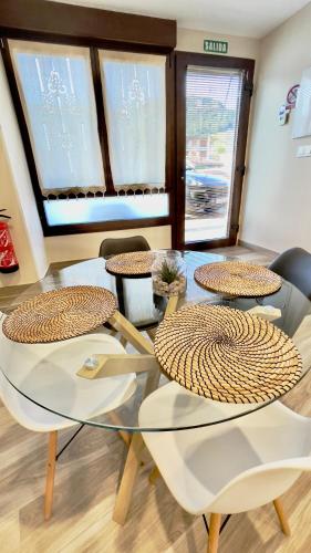a dining room with a glass table and chairs at Lapaserina-A in Arenas de Cabrales