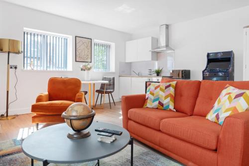 a living room with a orange couch and a table at Modern Studio in Arnold centre in Nottingham