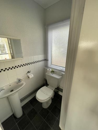 a white bathroom with a toilet and a sink at Captivating 2-Bed chalet in Bessingby