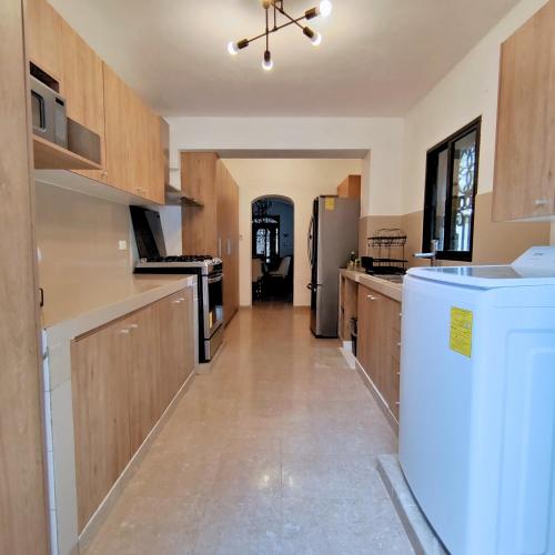 a large kitchen with wooden cabinets and a refrigerator at Colonial Villa in Merida Centro 4BR 3BA Private Pool Near Paseo de Montejo in Mérida