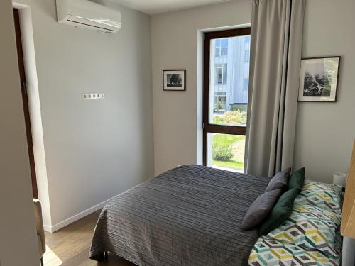 a bedroom with a bed and a window at 1-Bedroom Apartment by Šventosios vartai in Šventoji