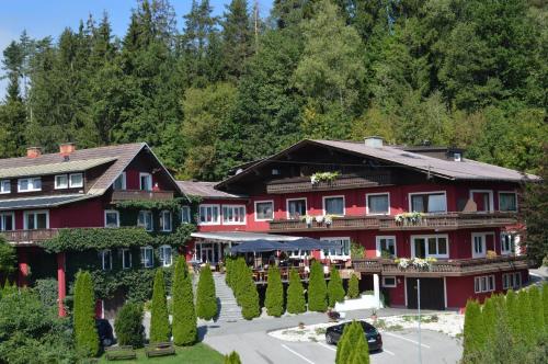 a large red building with trees in front of it at Landidyll-Hotel Nudelbacher in Feldkirchen in Kärnten
