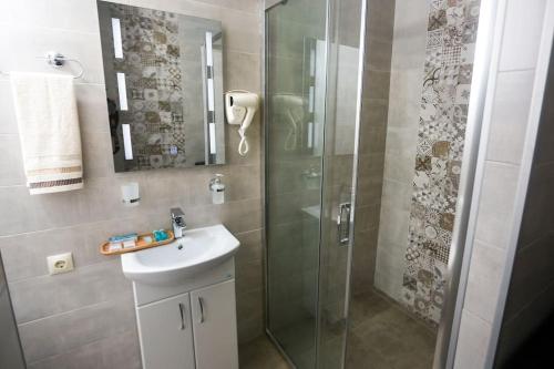 a bathroom with a shower and a sink and a mirror at Agmashenebeli Lilu's Apartment 2 in Tbilisi City