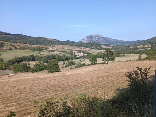 a large field with a mountain in the background at maison dans village rural in Saint-Louis-et-Parahou