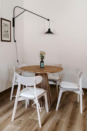 a dining room table with white chairs and a lamp at Sky and Vineyards - Nespolo - in La Morra