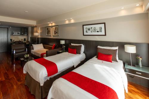 a hotel room with two beds and a living room at Urban Suites Recoleta Boutique Hotel in Buenos Aires