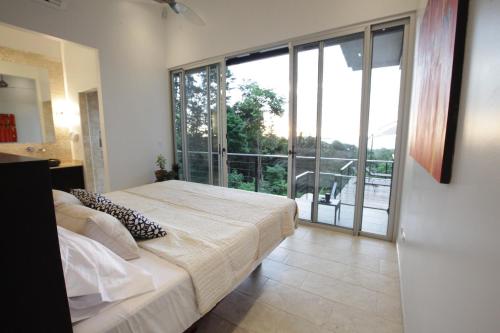 a bedroom with a large bed and a balcony at Ocean View Villa With Pool and Spectacular Sunsets in Ballena