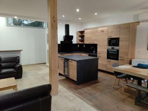 a large kitchen with a black island in a living room at La casa de Soto in Lourdes