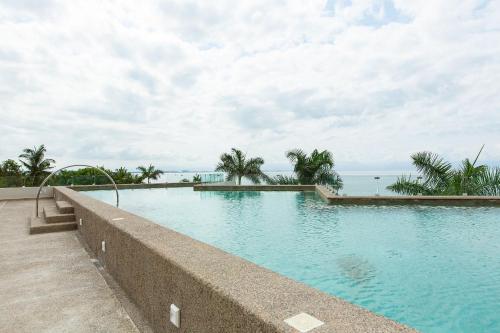 a swimming pool with the ocean in the background at Beachfront Condo, Zantamar 305 in Cruz de Huanacaxtle