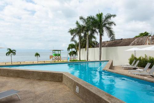 a swimming pool with a view of the ocean at Beachfront Condo, Zantamar 305 in Cruz de Huanacaxtle