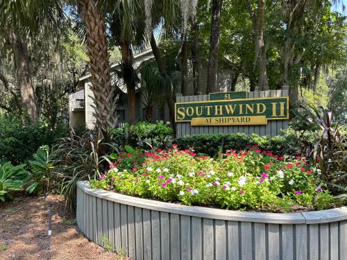 a sign for a southwind inn with flowers in a garden at Southwind II at Shipyard in Hilton Head Island