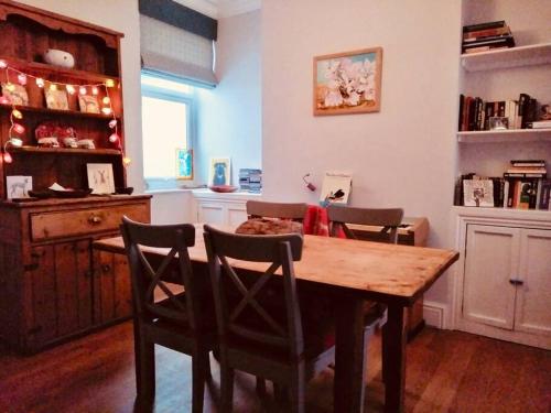 a dining room with a wooden table and chairs at Cosy Roath home near the park in Cardiff