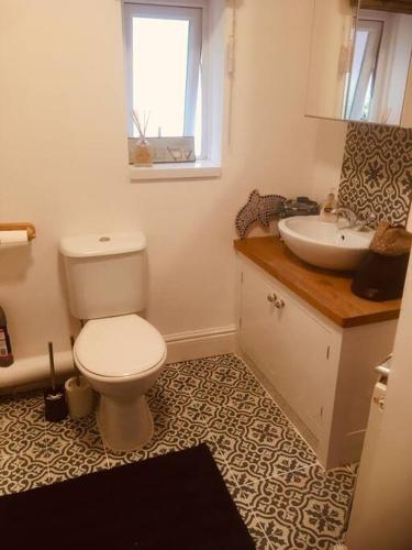 a bathroom with a white toilet and a sink at Cosy Roath home near the park in Cardiff