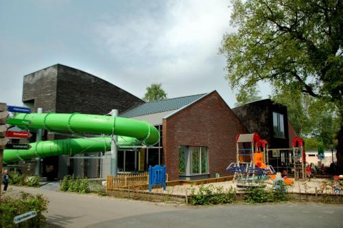 un edificio con uno scivolo d'acqua di fronte a un edificio di Chalet vakantiepark Kleine Belties 18 a Hardenberg