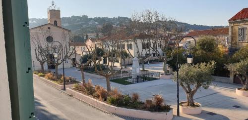 - une vue sur une rue de la ville avec des arbres et une église dans l'établissement jolie maison de village avec jardin, à Saint-Mandrier-sur-Mer