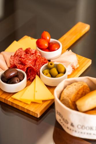 a cutting board with cheese and other foods on it at Urban Suites Recoleta Boutique Hotel in Buenos Aires