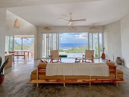 a bedroom with a large bed with a view of the ocean at Casa Deriva - Modern 3 Bedroom AC with Pool in Playa Maderas