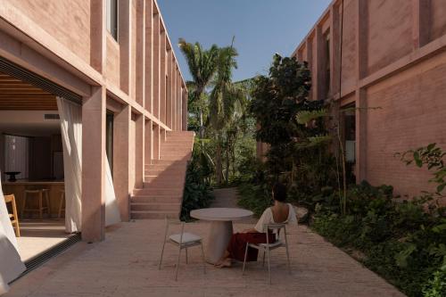 a woman sitting at a table next to a building at Rosa Morada Luxury Villas with Private Beach in San Francisco