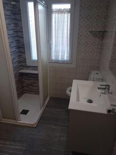 a bathroom with a sink and a shower with a window at Corme camiño dos faros, playa Galicia in Corme-Puerto