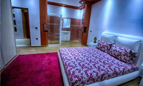 a bedroom with a bed and a pink rug at Villa Al Jaouhara in Essaouira
