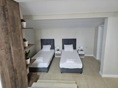 two beds in a room with white walls at Къща за гости SUNNY HILL in Varna City