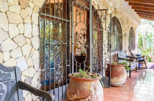 a porch with two large vases and a wrought iron gate at Quinta mi Tata B&B in Nuevo Colón