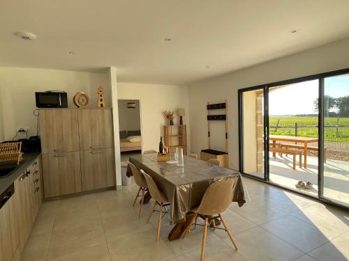 une cuisine et une salle à manger avec une table et des chaises dans l'établissement Les Gîtes De Roma, à Plogonnec