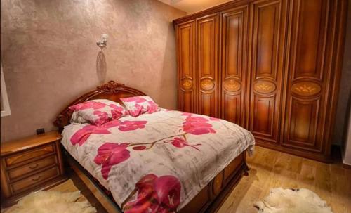 a bedroom with a bed with pink flowers on it at Villa Al Jaouhara in Essaouira