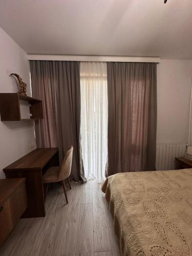 a bedroom with a bed and a desk and a window at Sunset Sea View Apartment Green Cape Batumi in Batumi