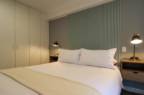 a bedroom with a white bed with two pillows at Monumental by Wynwood House in Lima