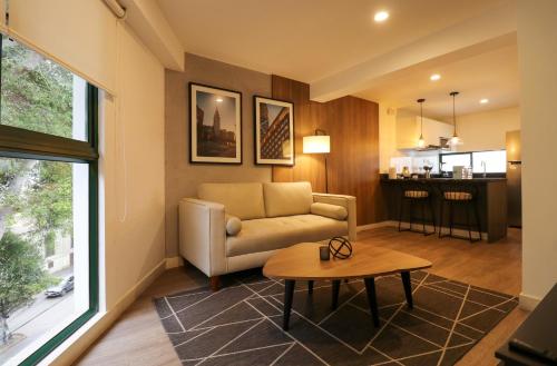 a living room with a couch and a table at Monumental by Wynwood House in Lima