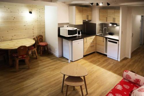 une petite cuisine avec une table et un micro-ondes dans l'établissement Résidence Le Silhourais - Très joli Studio 4 personnes idéal pour famille MAE-9331, aux Orres