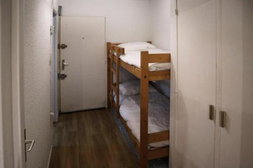 - 2 lits superposés dans une petite chambre avec une porte dans l'établissement Résidence Le Silhourais - Très joli Studio 4 personnes idéal pour famille MAE-9331, aux Orres