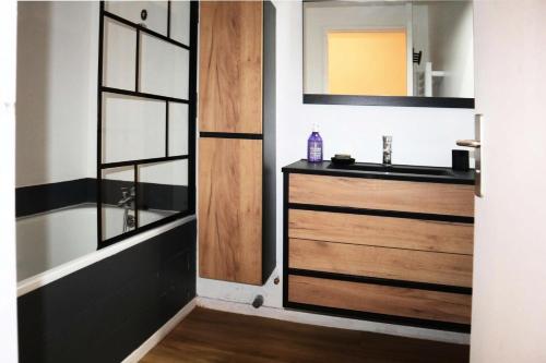 La salle de bains est pourvue d'un lavabo et d'une porte en bois. dans l'établissement Résidence Le Silhourais - Très joli Studio 4 personnes idéal pour famille MAE-9331, aux Orres