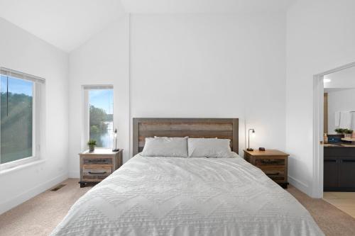 a white bedroom with a large bed and two windows at Turtle River Retreat in Ottawa