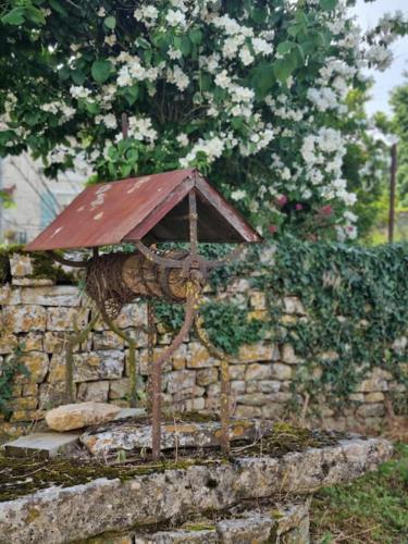a statue of an umbrella on a stone wall at Gite Mani et Princesse à partir de 2 à 6 personnes in Sainte-Soline