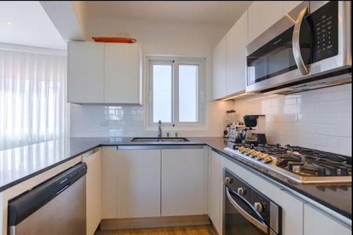 a kitchen with white cabinets and a stove top oven at Stanza Mare Beach Front in Punta Cana