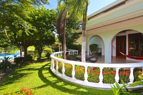 a house with a white fence and flowers at Villa del Sueño in Playa Hermosa