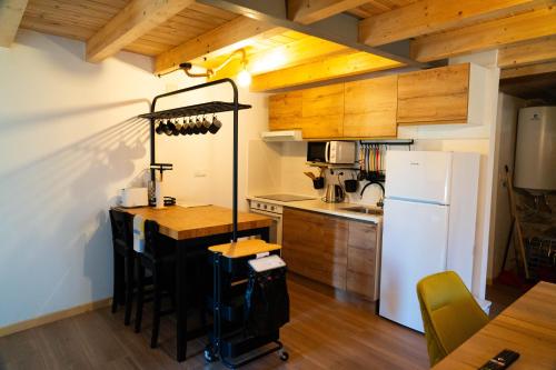 a kitchen with a table and a white refrigerator at O Vicedo Beach Resort WEST in O Vicedo