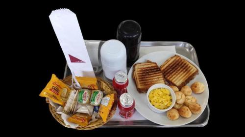 Una bandeja con una cesta de comida, huevos y pan. en Motel Zurich, en São Paulo