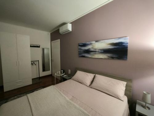 a bedroom with a bed and a painting on the wall at Locazione Lilibet in Conegliano