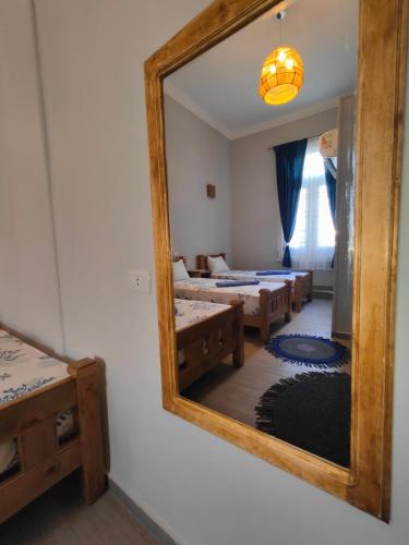 a mirror on the wall of a room with two beds at Champollion Palace in Cairo