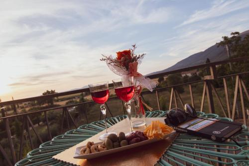 a table with two glasses of wine and a plate of food at Bully casa Vacanze in Spello
