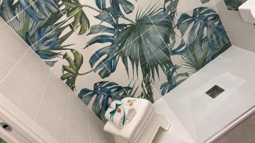 マリーナ・ディ・カメロータにあるResidence Torre Delle Violeの壁に植物の壁画が施されたバスルーム
