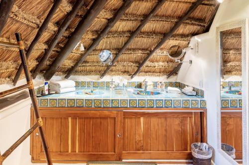 a bathroom with a wooden vanity with a blue tiled counter at Casa de Los Vientos Soliman Bay in Tulum