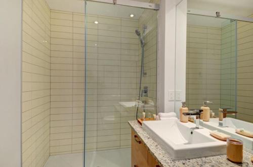 a bathroom with a sink and a glass shower at Les Immeubles Charlevoix - Le 760214 in Quebec City