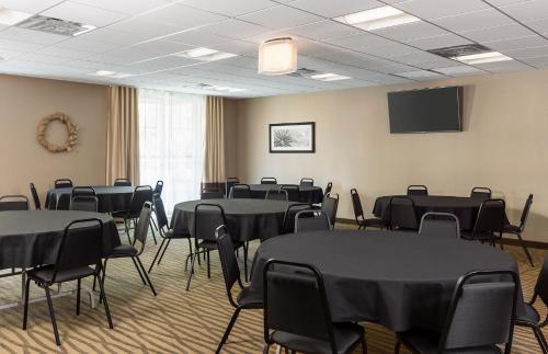 a room with tables and chairs and a tv at Comfort Suites Hartville-North Canton in Uniontown