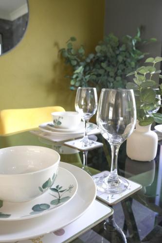 a table with two wine glasses and a bowl at Ten Acres House in Sauchie